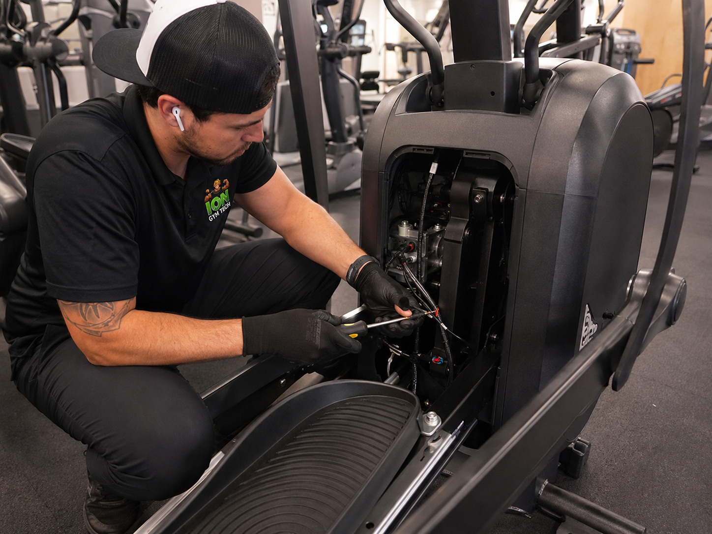 IONGymTech technician repairing a commercial elliptical machine