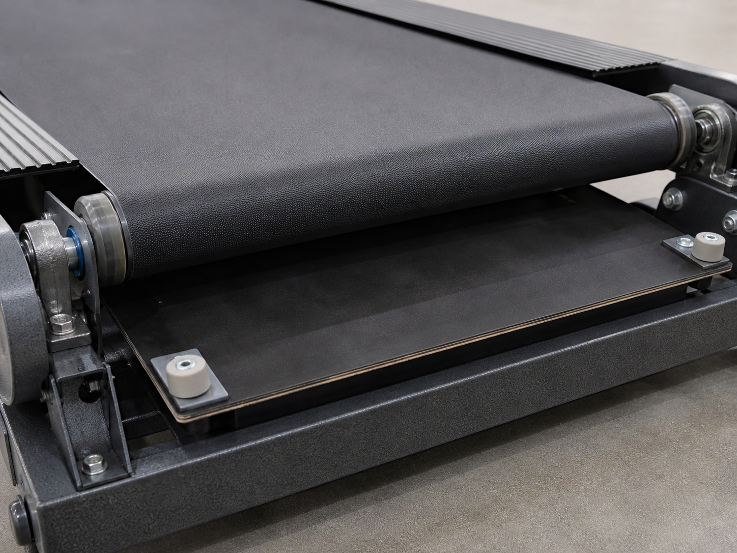 Exposed treadmill walking deck, belt, rollers, bearings, and mounting hardware