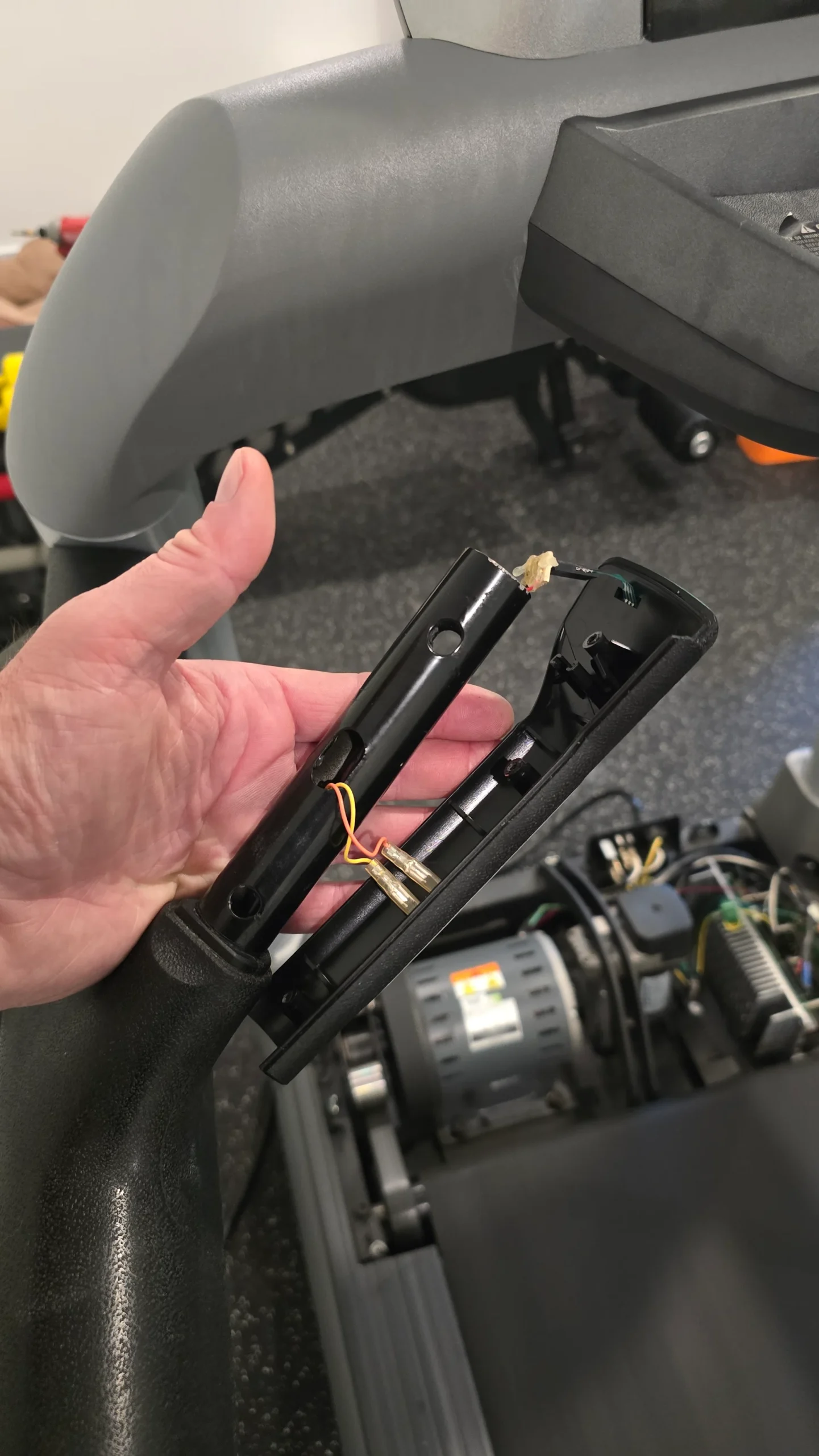 Fitness equipment component undergoing hands-on diagnostic repair